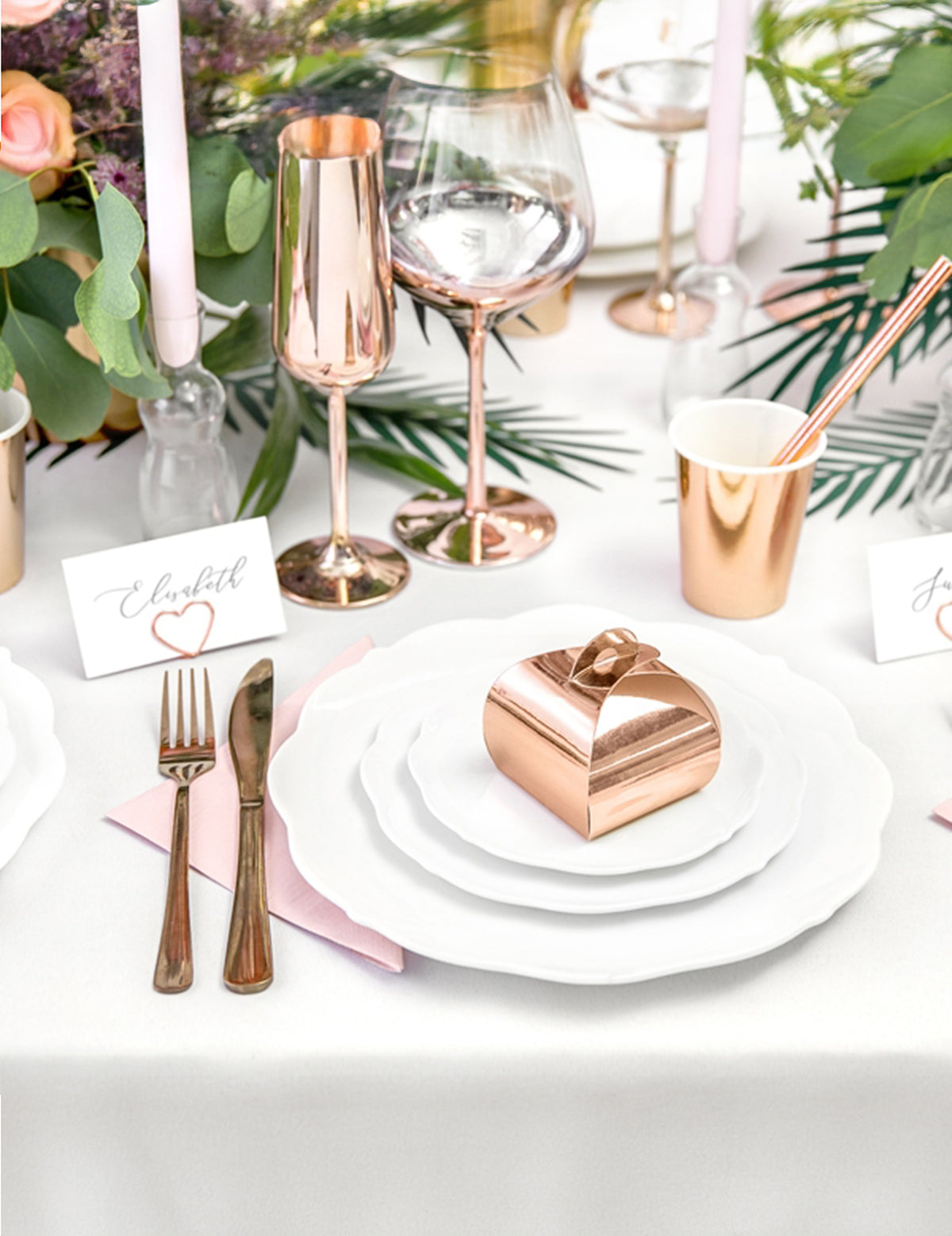 Mise en scène sur une assiette de la boîte en carton à dragées rose gold métallisée