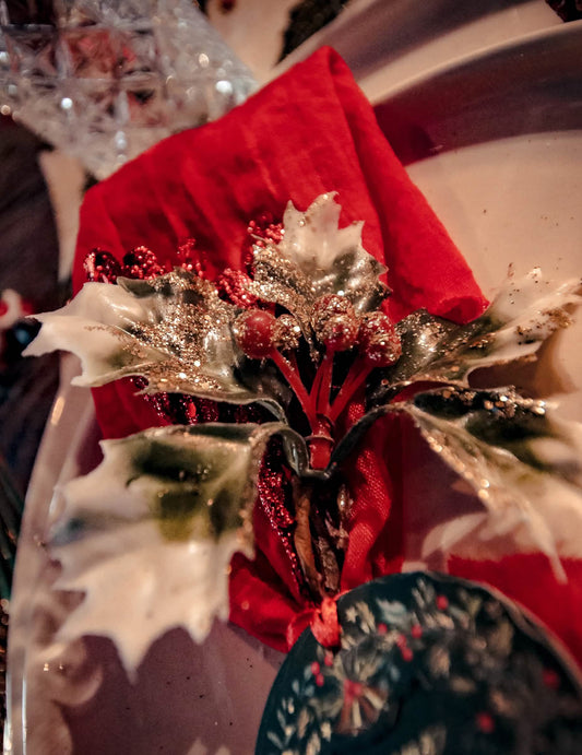 Gros plan sur les paillettes et baies rouges des branches de houx sur tige de Noël