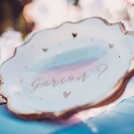 Gros plan sur l'inscription des assiettes en carton fille ou garçon pour baby shower