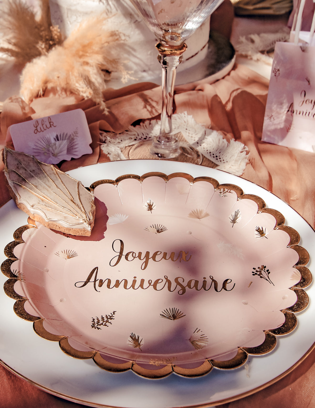 Mise en situation sur une table des assiettes Joyeux Anniversaire Boho