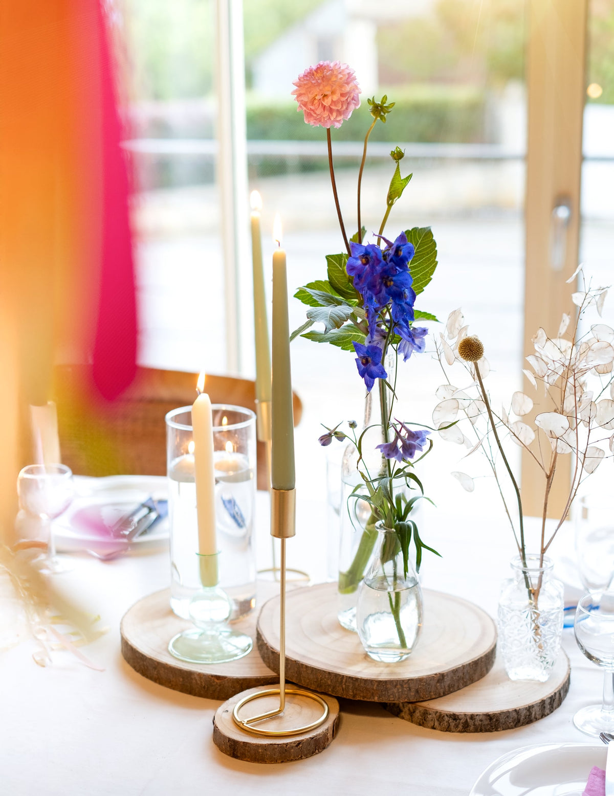 Mise en scène avec fleurs et bois naturel du bougeoir design sur pied pour table métal doré