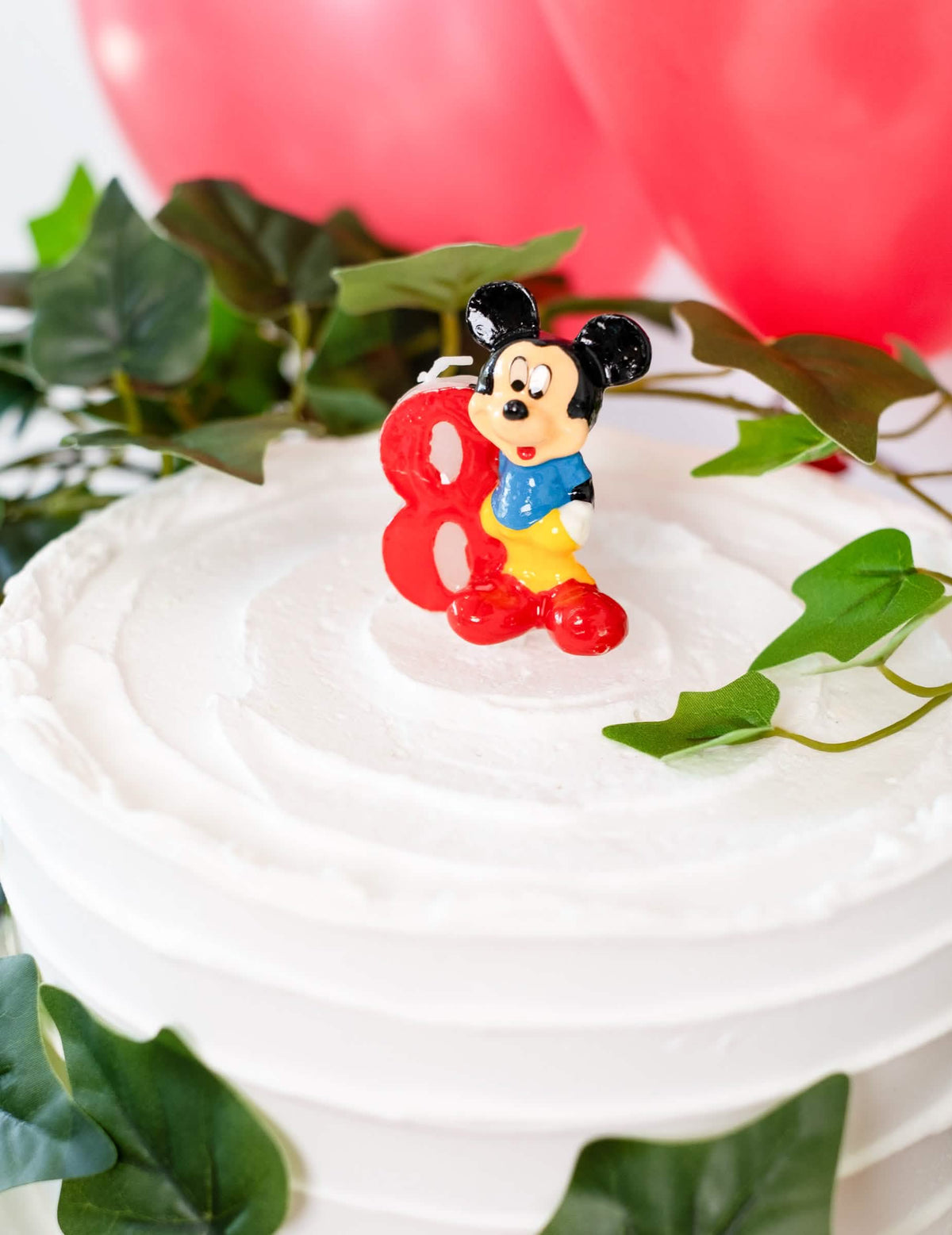 Közelkép a Mickey egér 8-as számú gyertyájával díszített tortáról