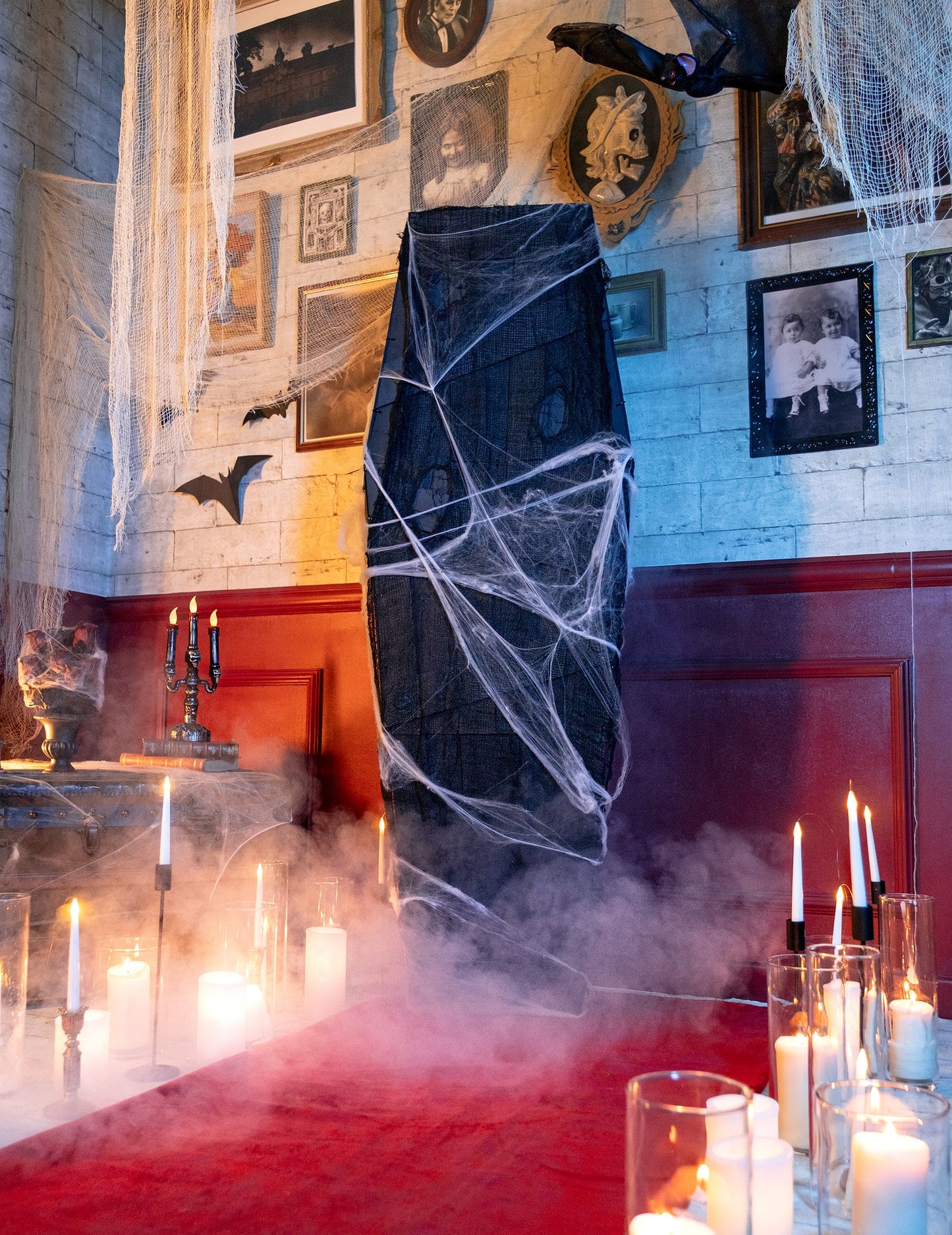 Halloweeni koporsó dekoráció fehér pókhálóval gyertyákkal és füsttel való beállítása