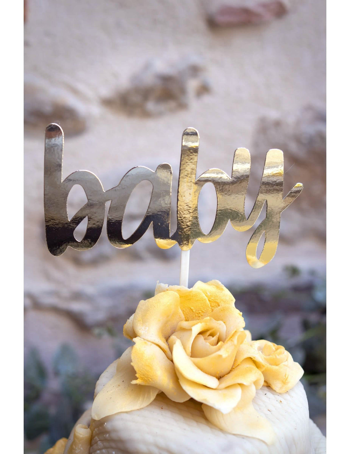 Közelkép a baby showerhez való tortadekoráció arany szövegéről