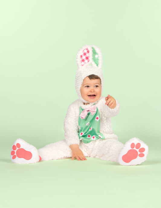 Bébé assis pointant du doigt du déguisement de lapin pour bébé