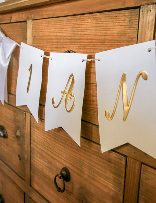 Vue de profil des fanions de la guirlande 1 an pour anniversaire blanche et dorée