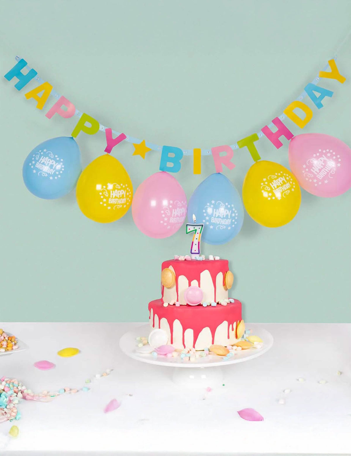 Jelenet tortával és lufikkal a Happy Birthday betűfüzérről