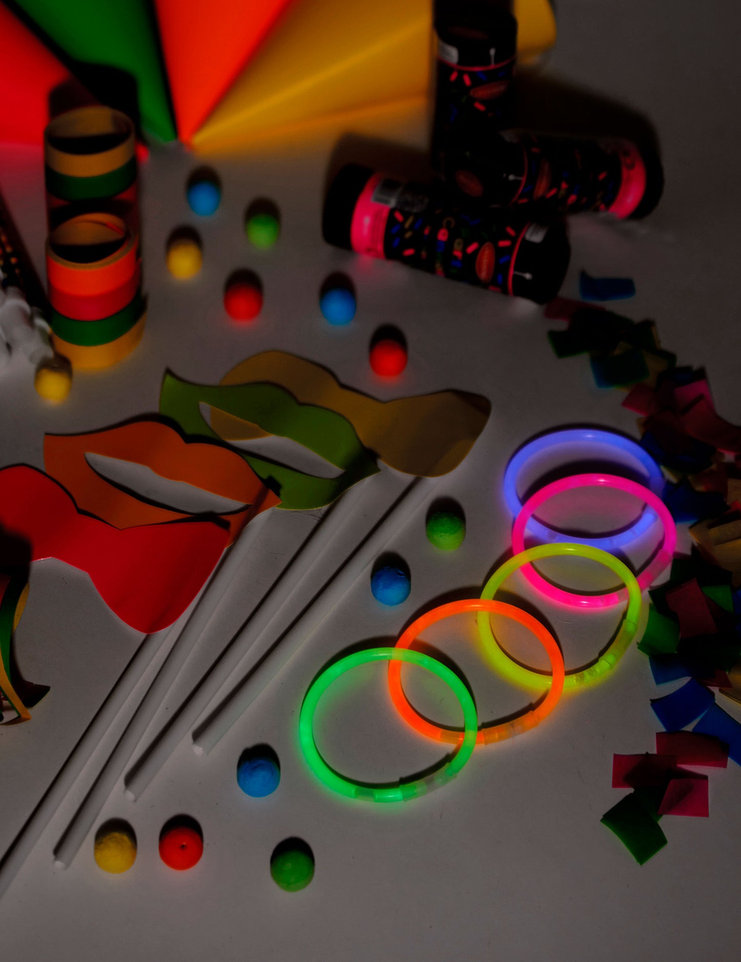 Détail des accessoires photobooth et bracelets fluorescents du kit cotillons fluo pour 8 personnes