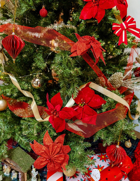Mise en situation sur un sapin de Noël du nœud de poinsettia avec grelots pour décoration de table