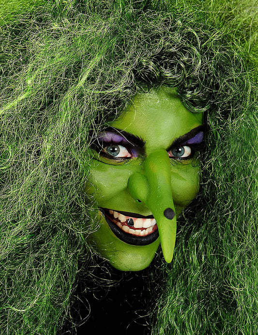 Gros plan sur le visage maquillé en sorcière du maquillage professionnel à l'eau pour visage et corps vert