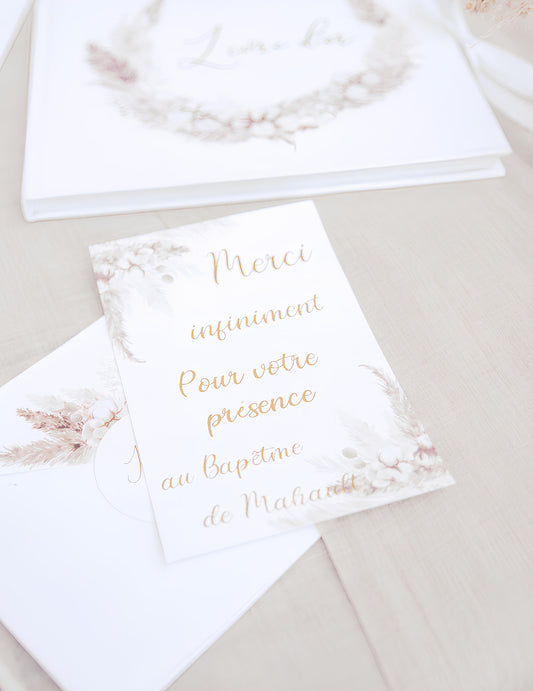 Gros plan sur le texte des invitations avec enveloppes pampas et fleurs de coton