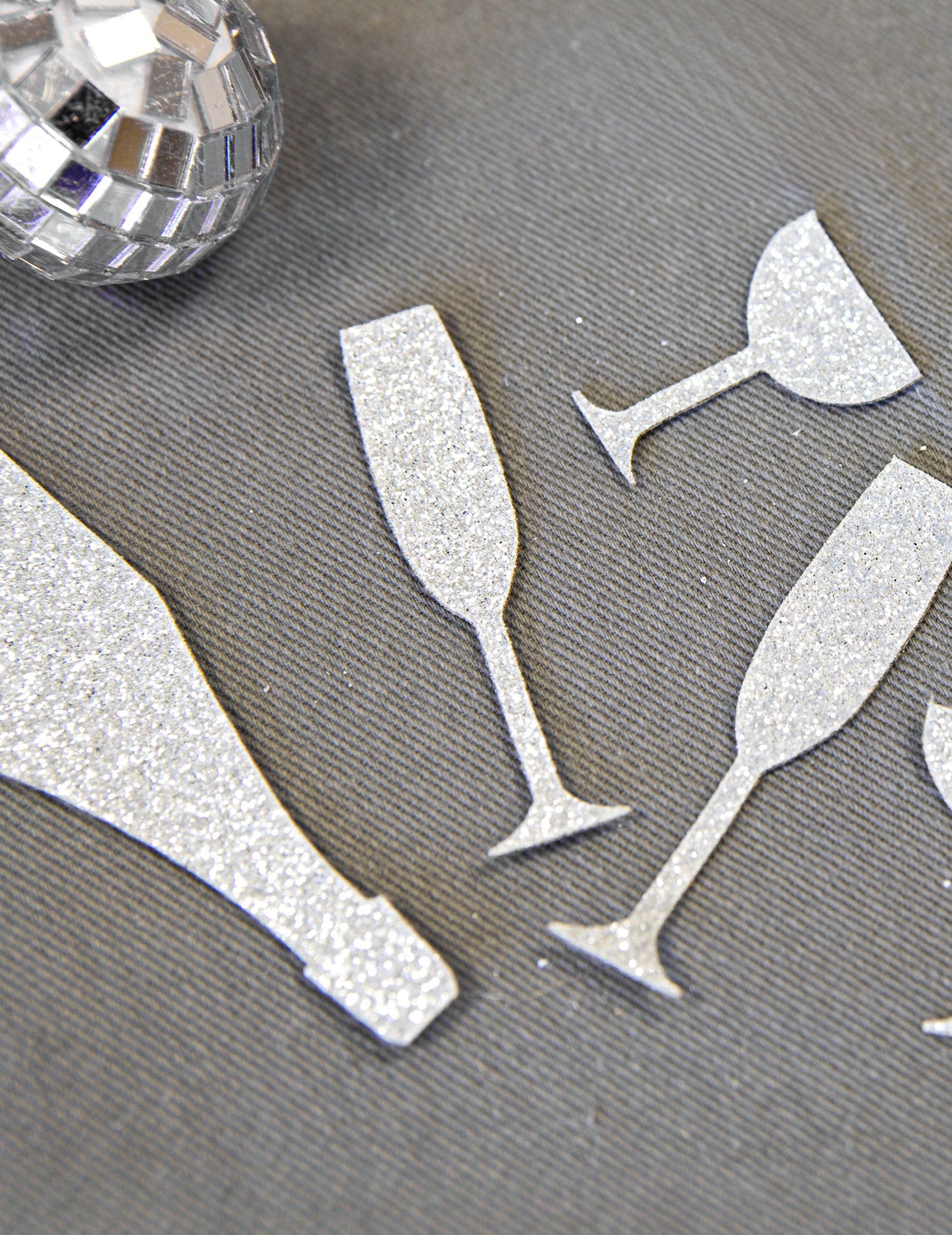 Gros plan sur la texture pailletée des confettis de table champagne argentés coupes et flûtes