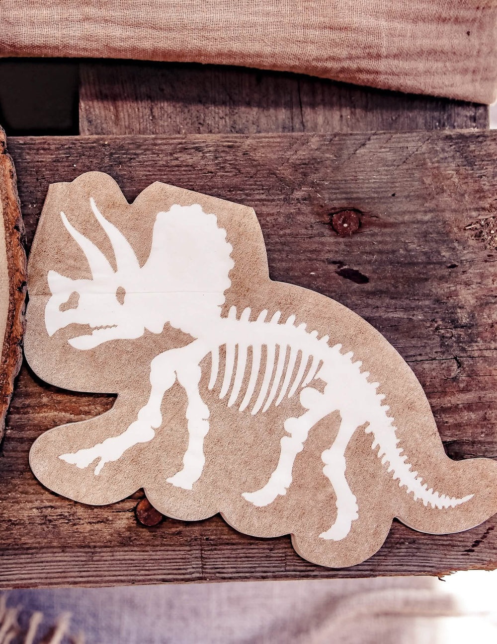 Détail du motif des serviettes dinosaures squelette tricératops