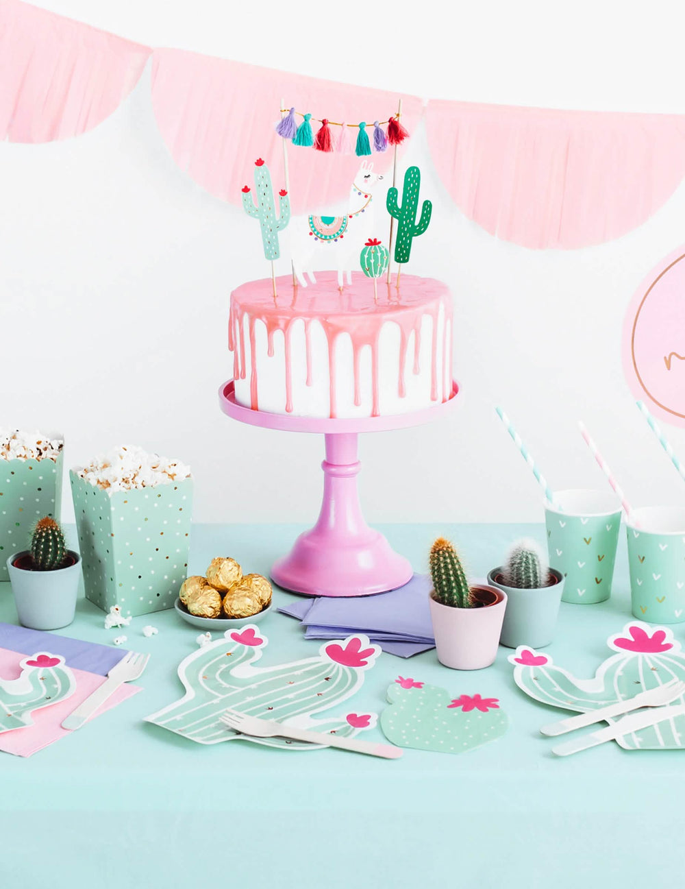 Ünnepi asztalon elhelyezett mentaszínű és fukszia kaktuszos papírszalvéták