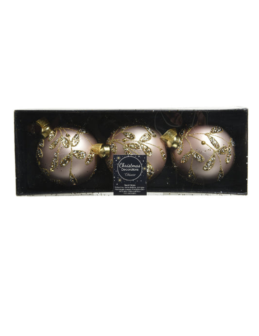 Vue dans leur coffret des boules de noël en verre rose poudré avec feuilles dorées à paillettes