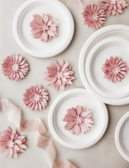 Mise en scène sur des assiettes des fleurs en papier 3D pour décoration rose poudré