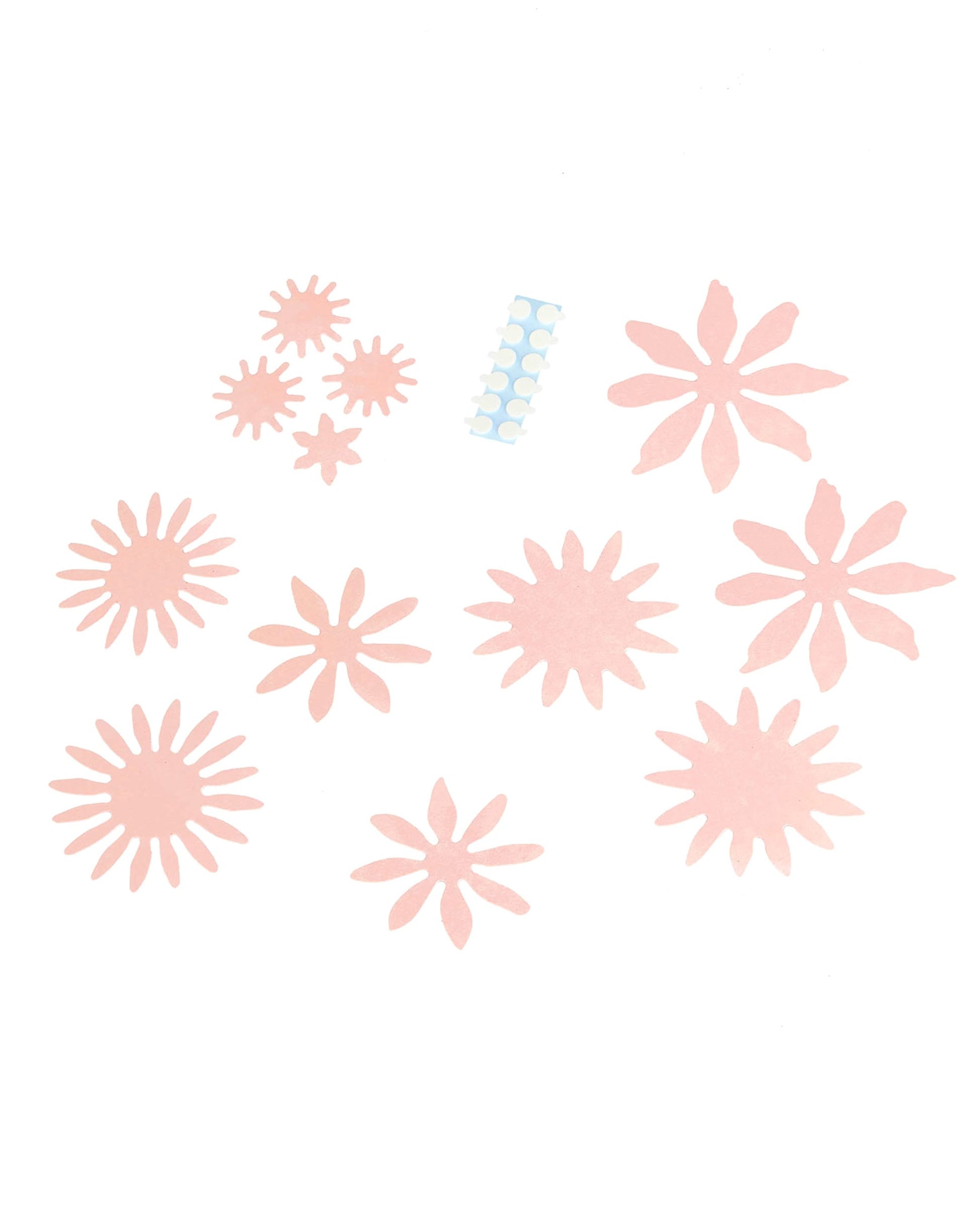 Détail des éléments et des pastilles adhésives des fleurs en papier 3D pour décoration rose poudré