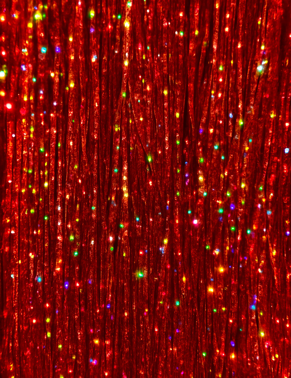 Gros plan sur la texture des mèches brillantes pour femme rouges à paillettes