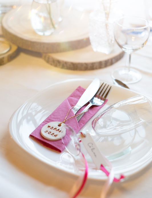 Mise en situation sur une table des serviettes en papier pour fête fuchsia
