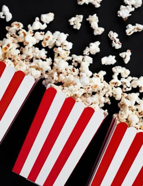 Kiömlött popcorn piros-fehér csíkos karton popcornos dobozokból