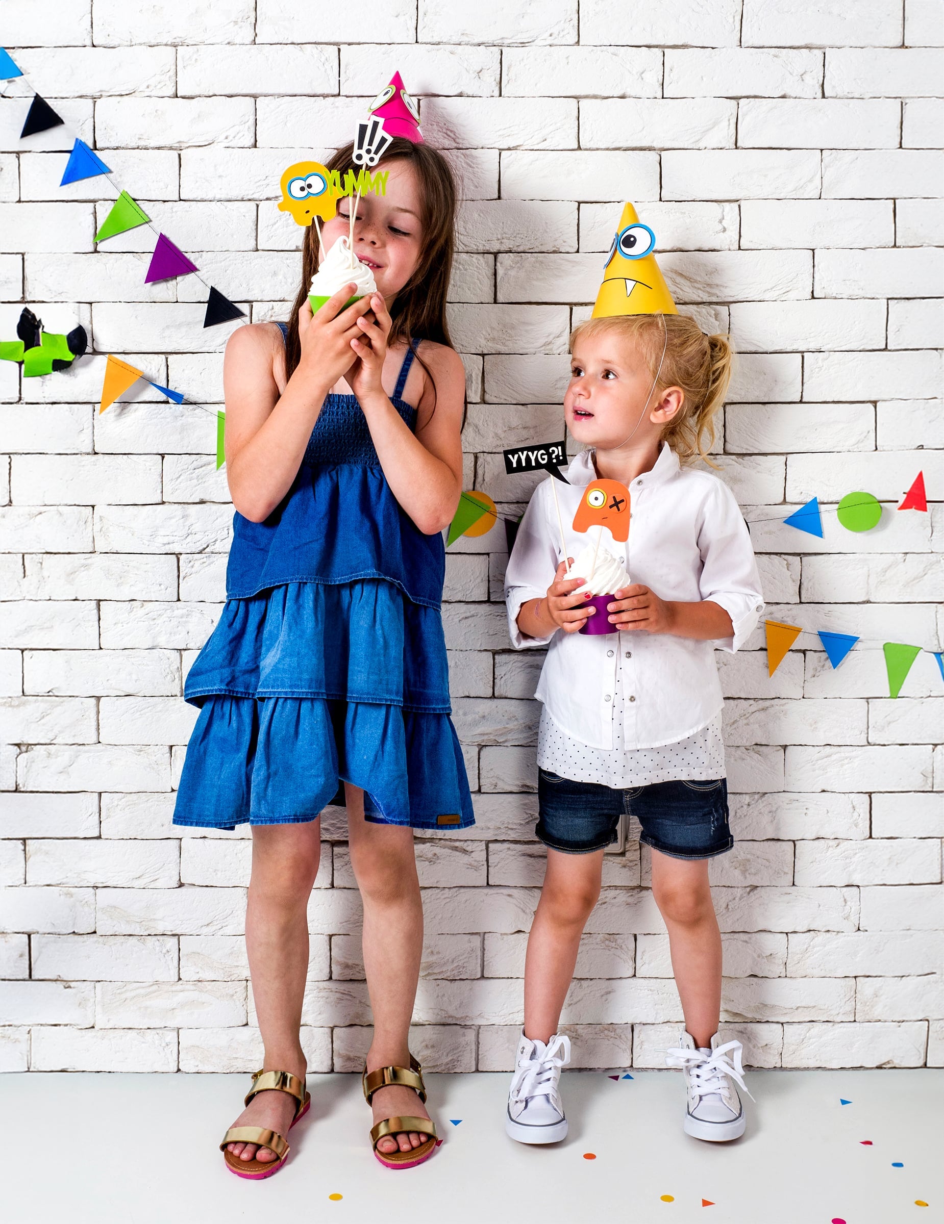 Enfants portant les chapeaux rose et jaune du chapeaux de fête petits monstres