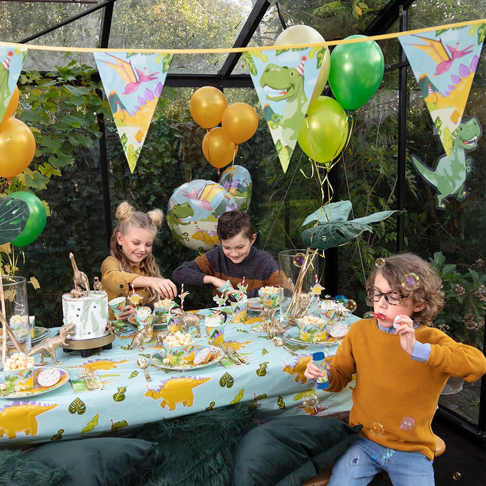 Mise en situation sur une table de fête des gobelets en carton Dino Party