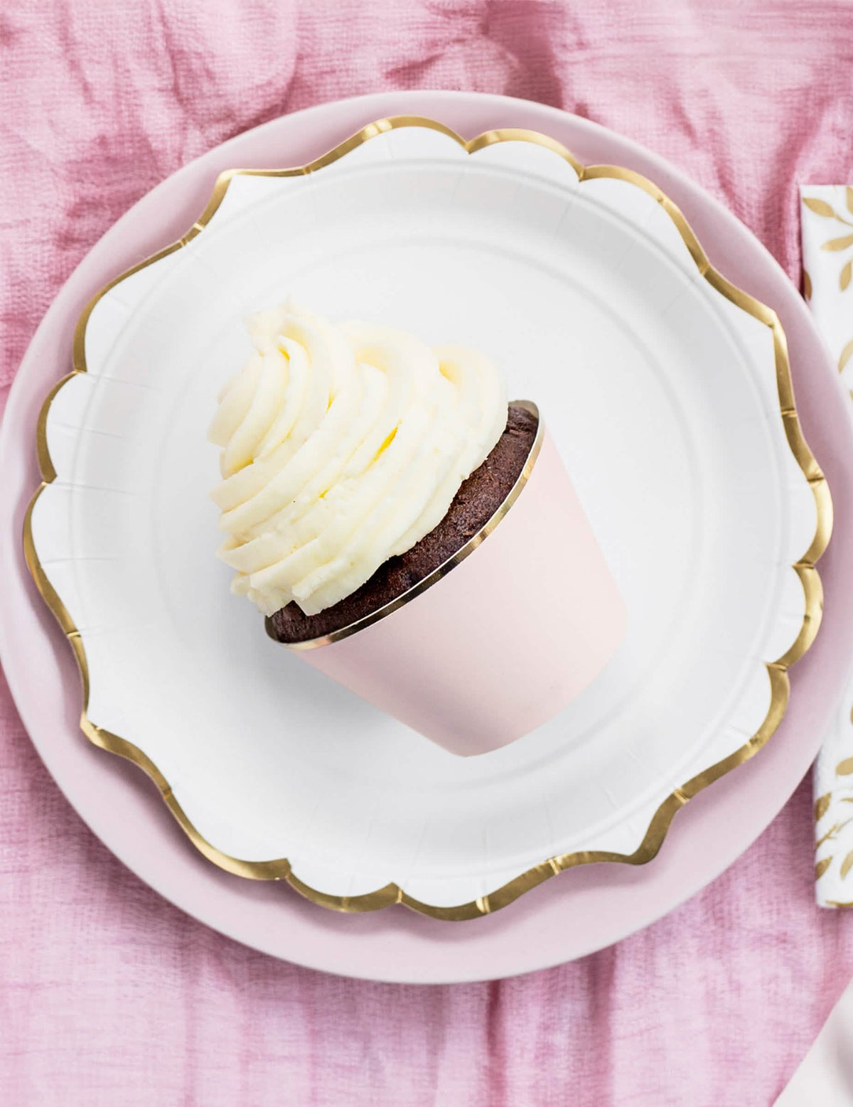 Közelkép púderrózsaszín és fémes arany cupcake papír díszekről