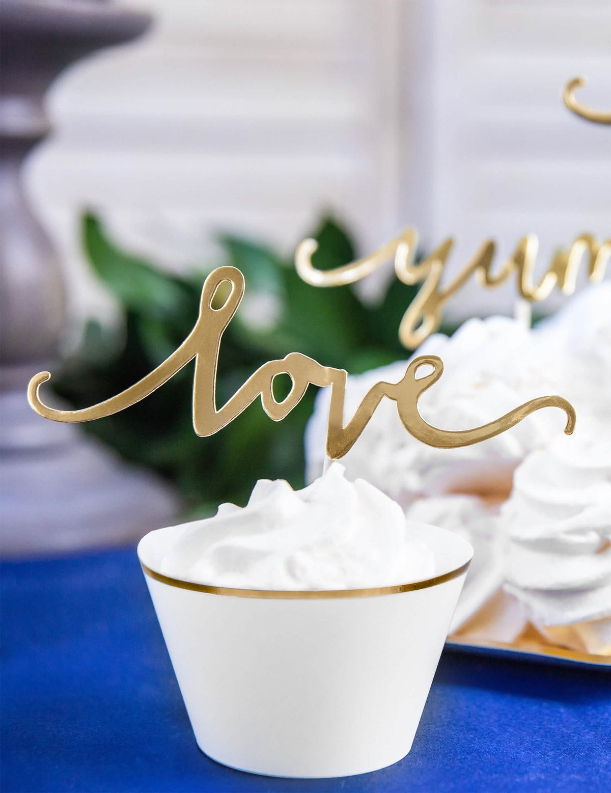 Nagyított kép az arany love cake topperről és a papír cupcake-toperekről esküvőre