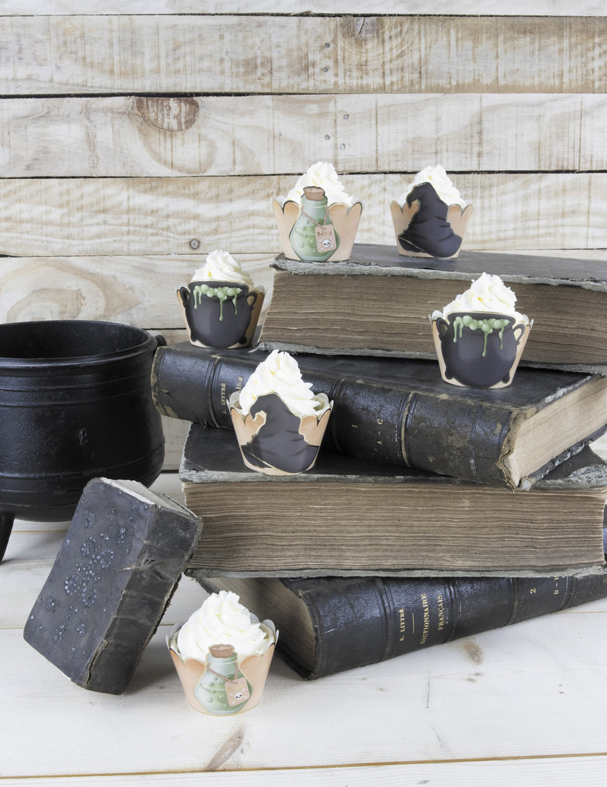 Mise en scène sur des livres anciens des habillages moules à cupcake apprenti sorcier