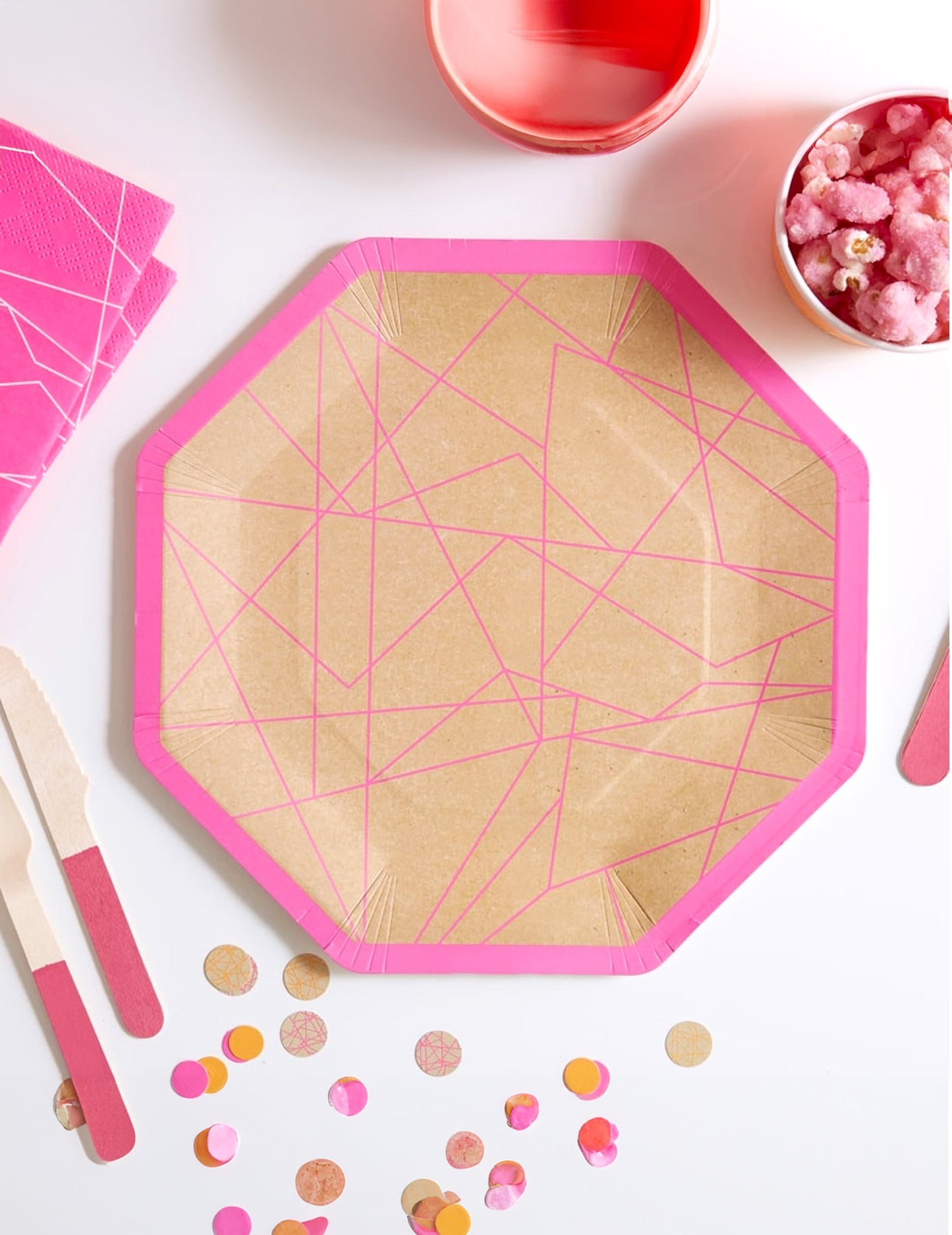 Vue de dessus des assiettes en carton kraft géométrique pour fête rose néon octogonales