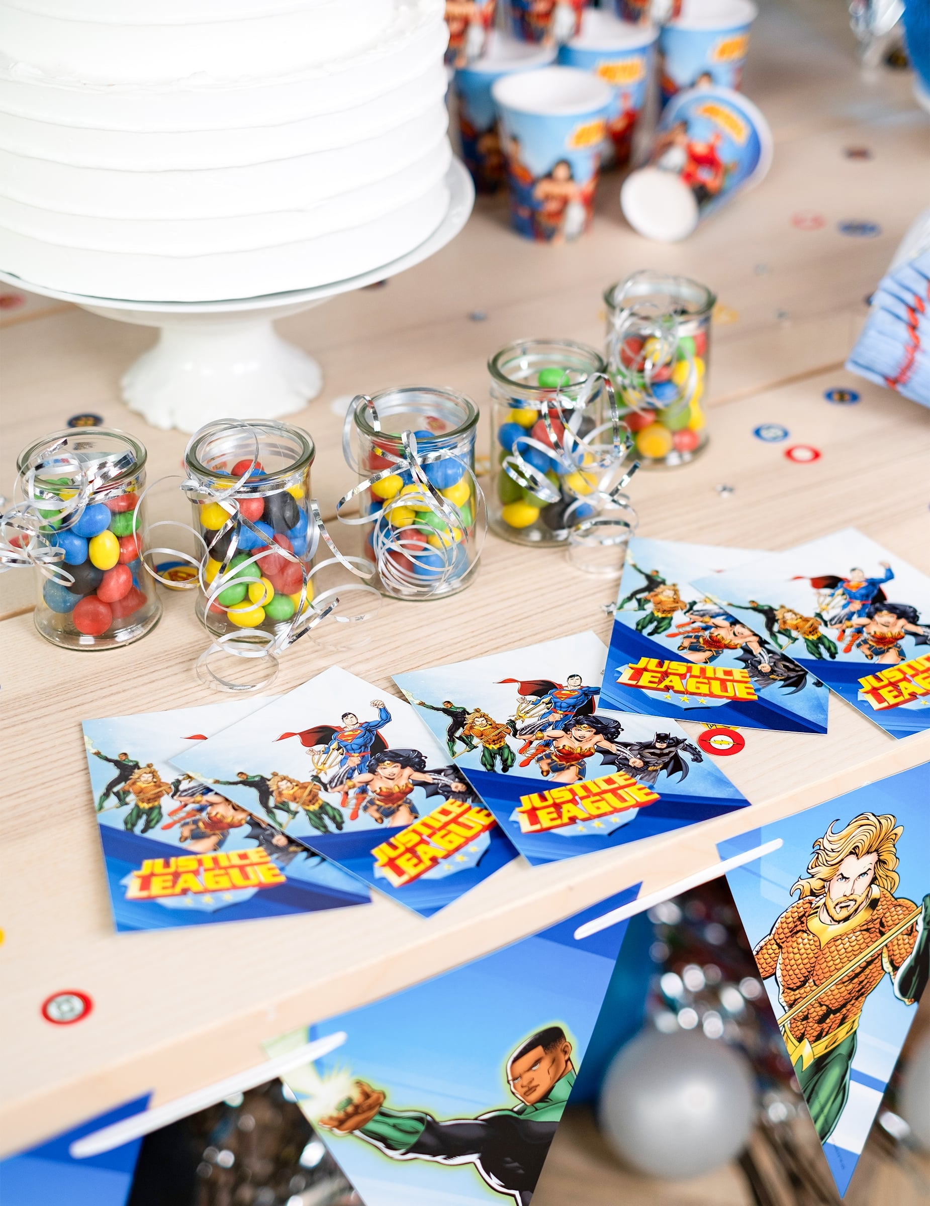 Mise en scène sur une table de fête des cartes d'invitation avec enveloppes Justice League