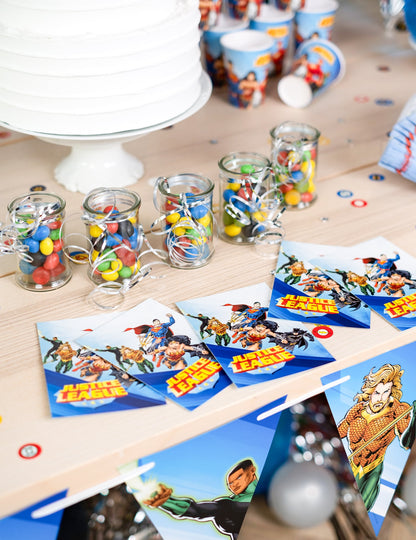 Mise en scène sur une table de fête des cartes d'invitation avec enveloppes Justice League