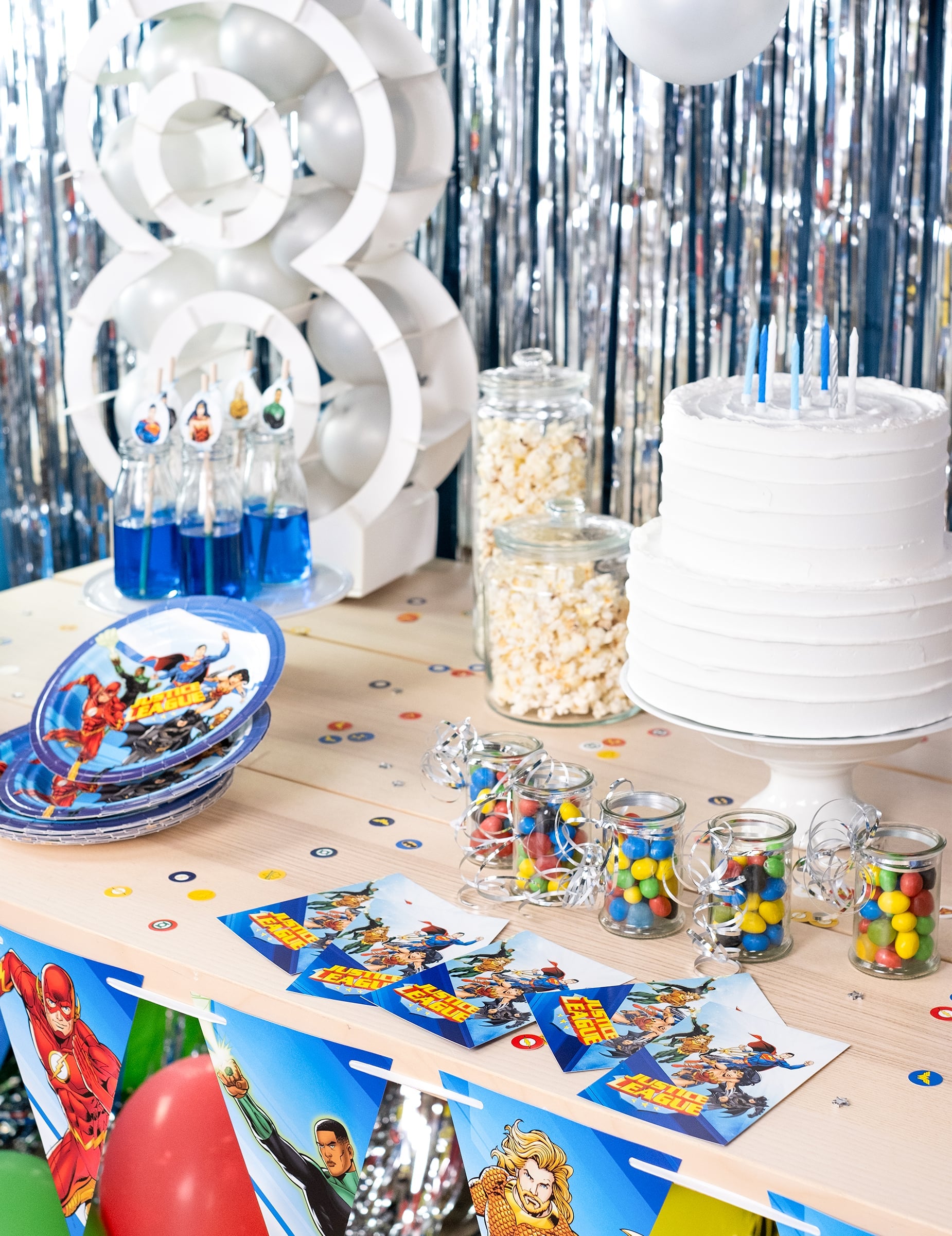Mise en situation sur une table d'anniversaire des cartes d'invitation avec enveloppes Justice League