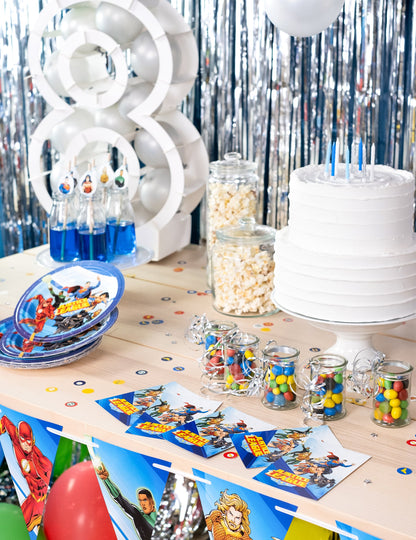 Mise en situation sur une table d'anniversaire des cartes d'invitation avec enveloppes Justice League