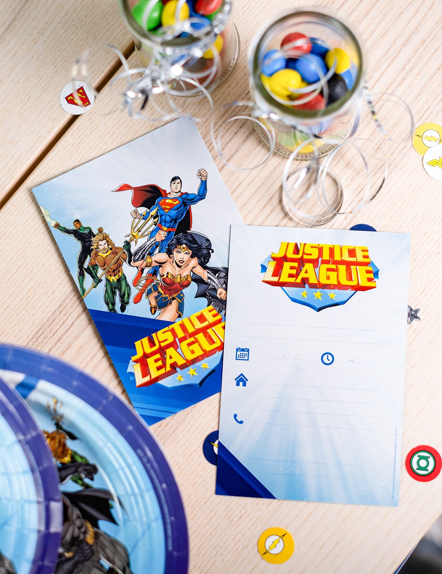 Mise en scène avec bocaux de bonbons des cartes d'invitation avec enveloppes Justice League