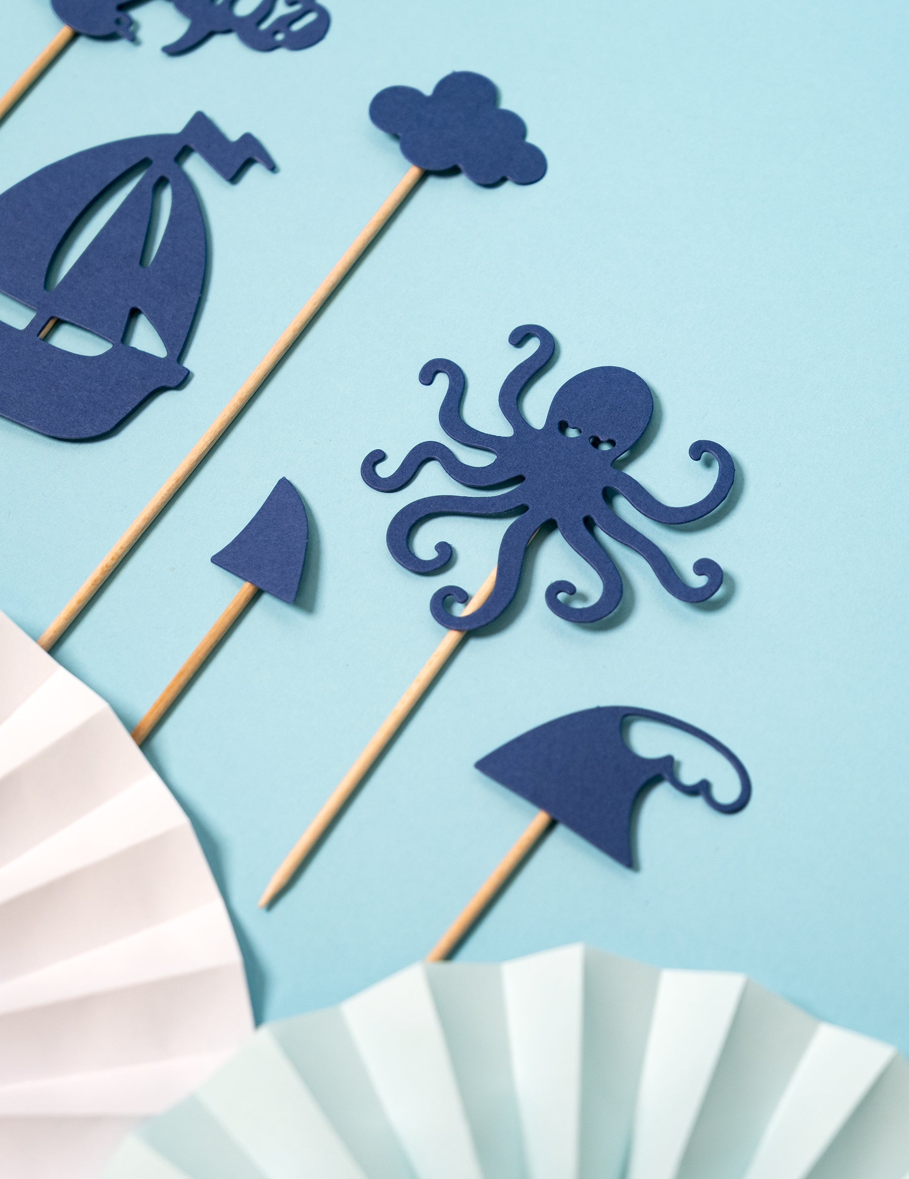 Gros plan sur les motifs pieuvre et bateau des décorations pour gâteau sur pique motifs mer