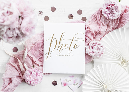 Mise en scène avec décor floral de l'album photo mariage blanc et doré