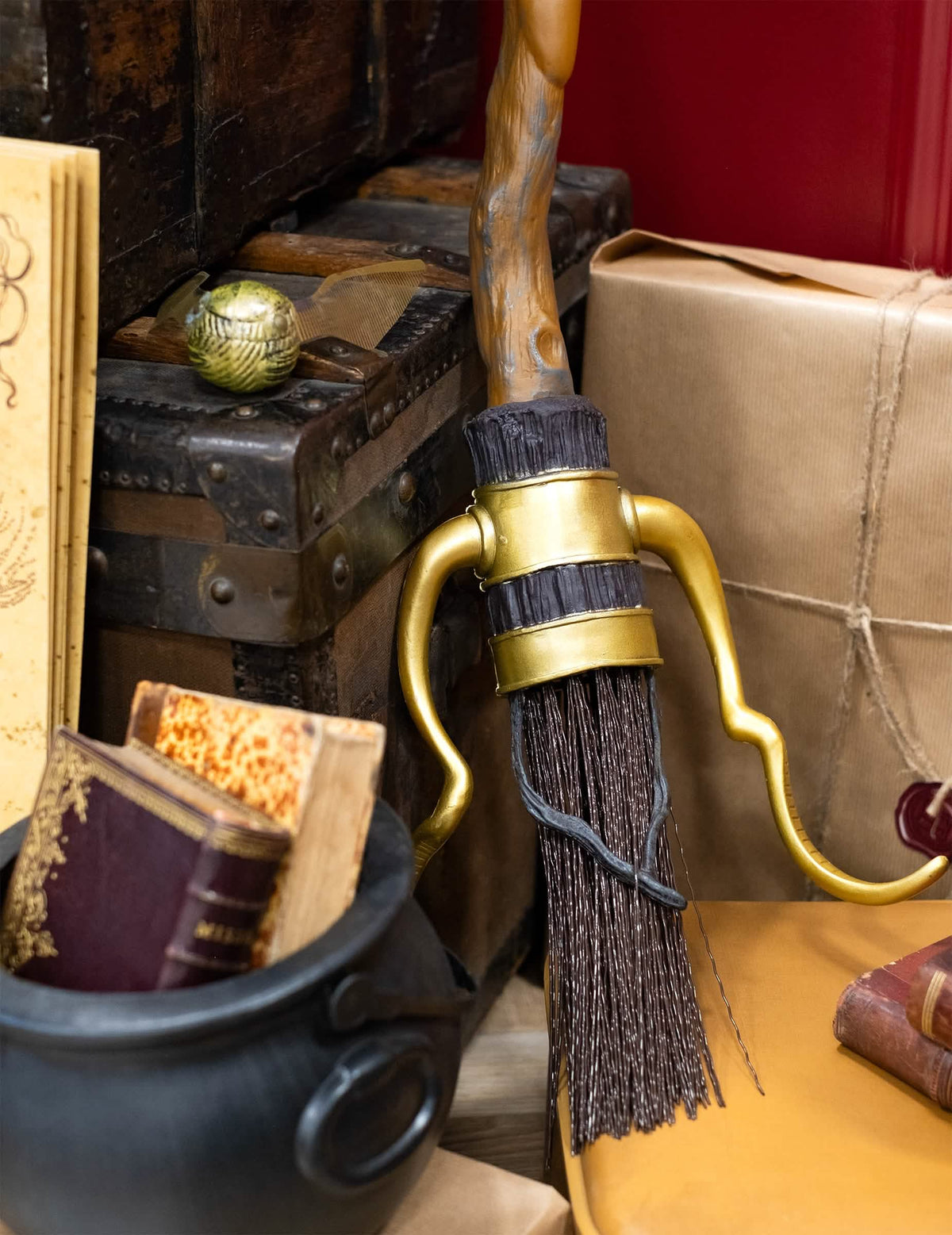 Közelkép az arany lábtartókról és a Nimbus luxus Harry Potter seprű szálairól