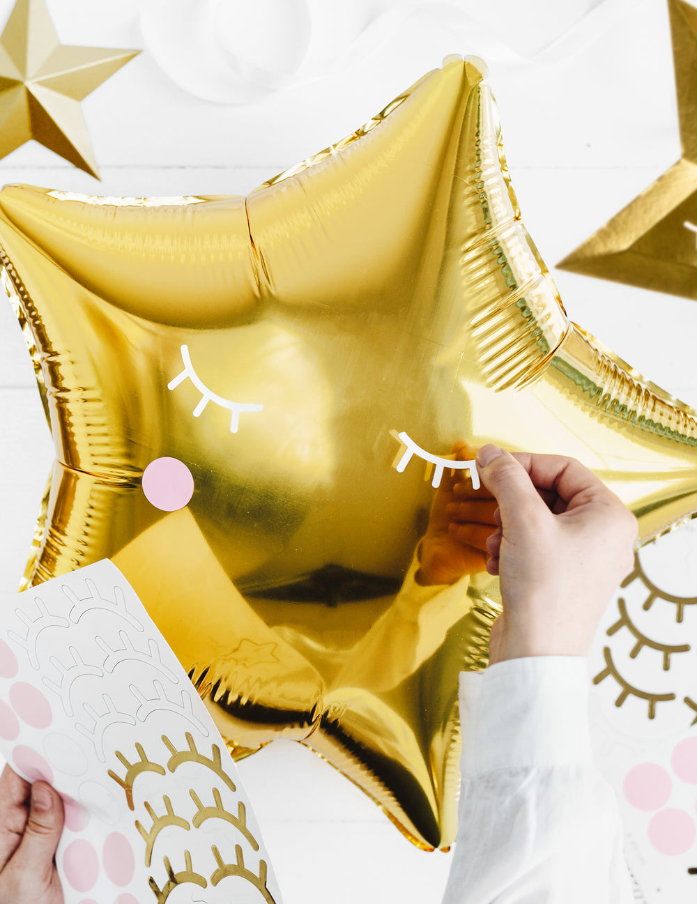 Détail de la personnalisation avec stickers du ballon aluminium étoile pour fête dorée