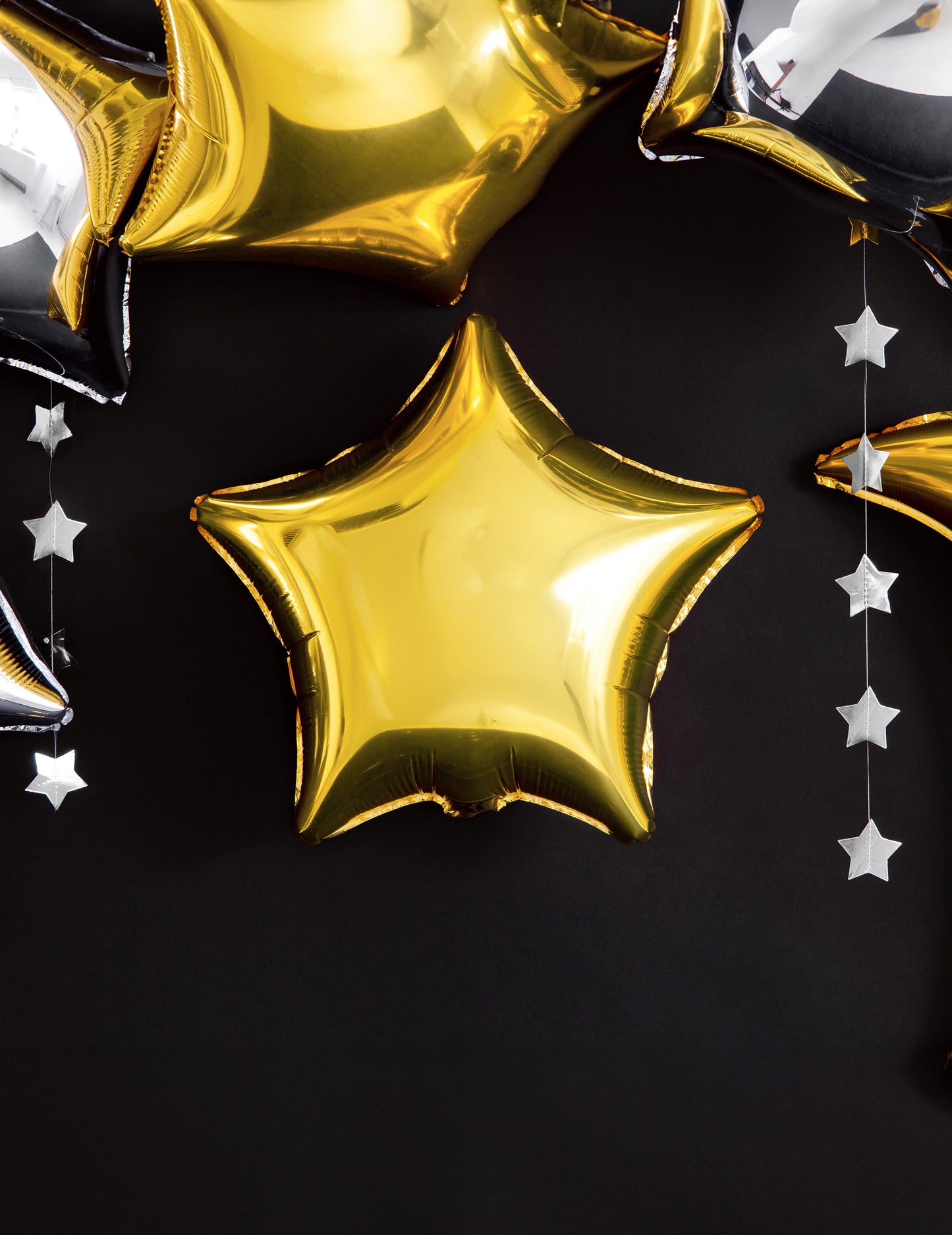 Composition décorative sur fond noir du ballon aluminium étoile dorée