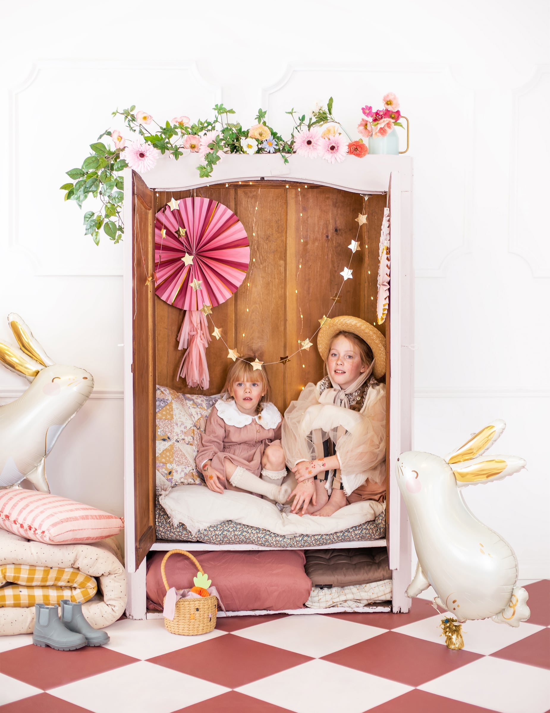 Mise en scène de deux enfants dans une armoire décorée du ballon aluminium lapin pour Pâques