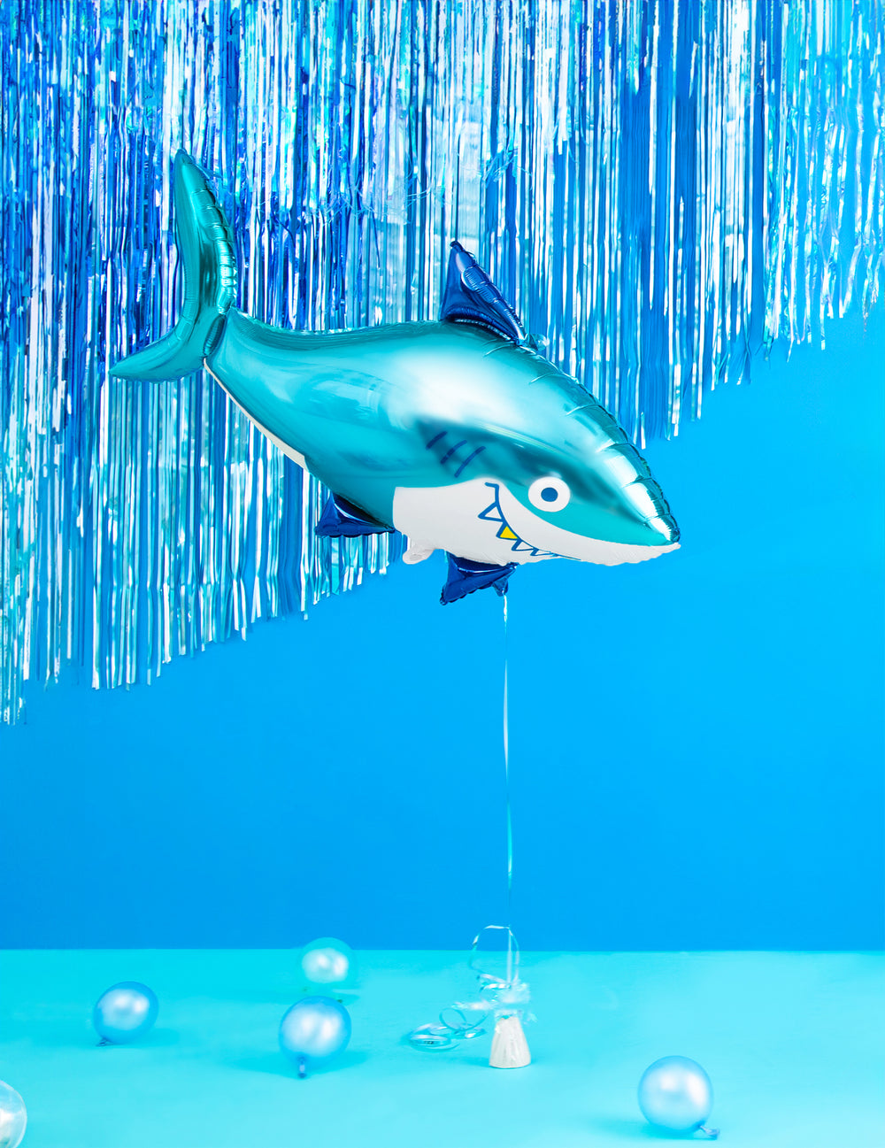 Mise en scène avec rideau bleu du ballon aluminium requin pour anniversaire océan