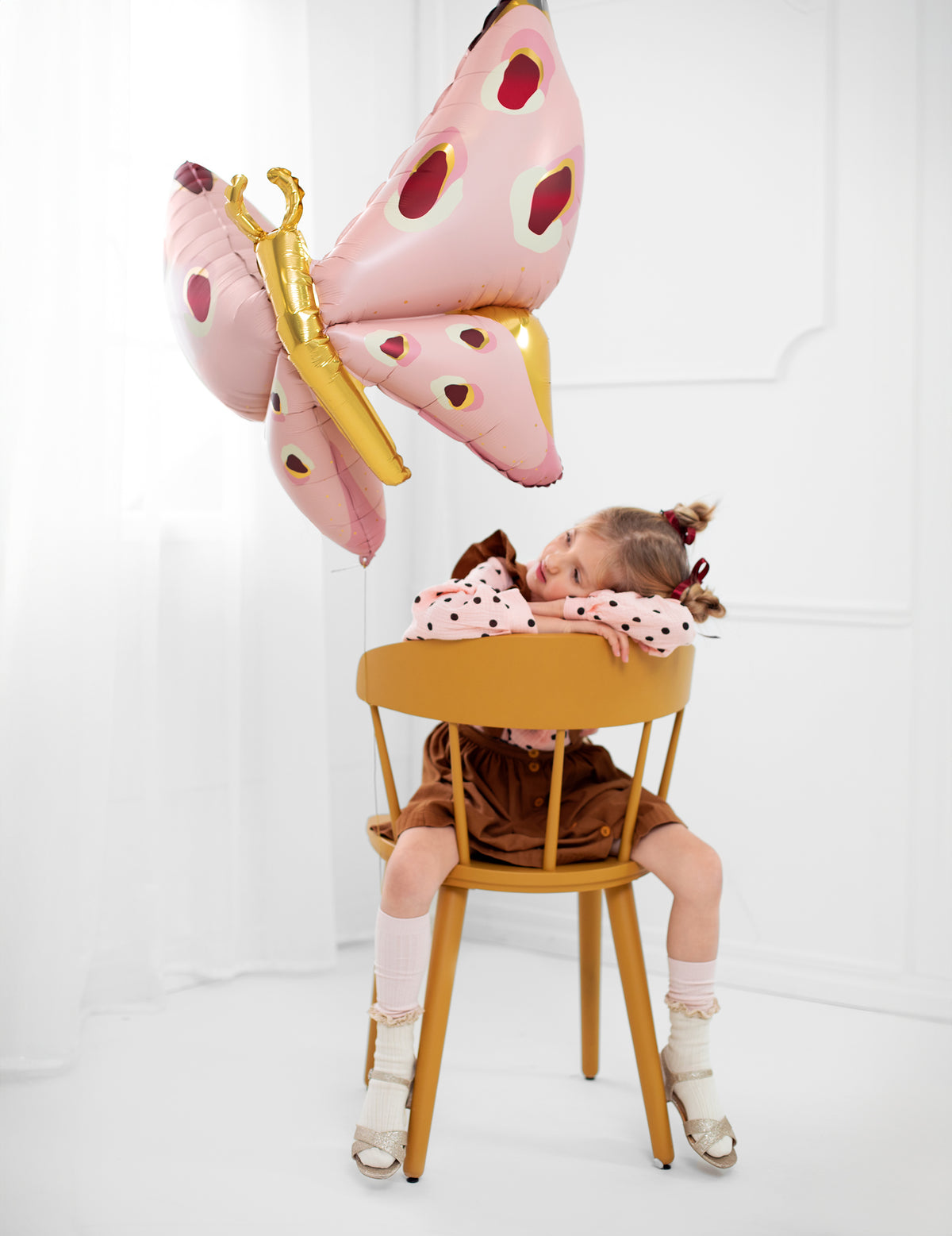 Mise en situation avec une enfant assise du ballon géant en aluminium papillon