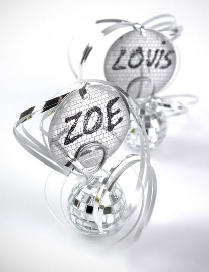 Mise en situation avec porte-noms et boules à facettes du bolduc brillant pour décoration de fête argent