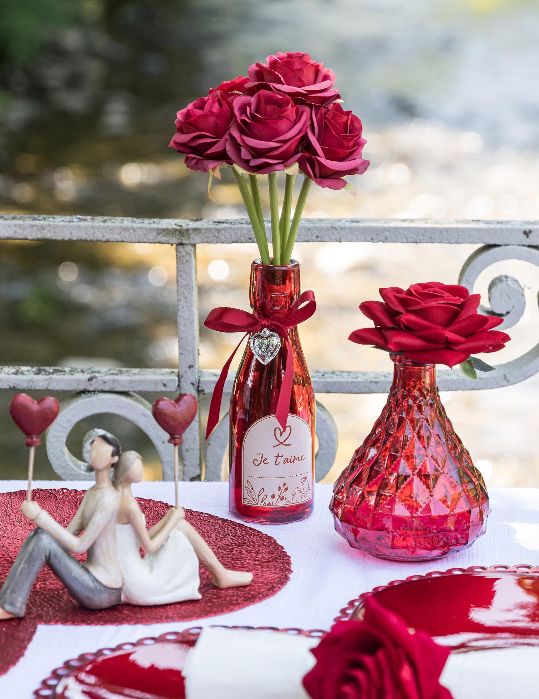 Mise en scène avec fleurs de la bouteille en verre coeur Je t'aime rouge
