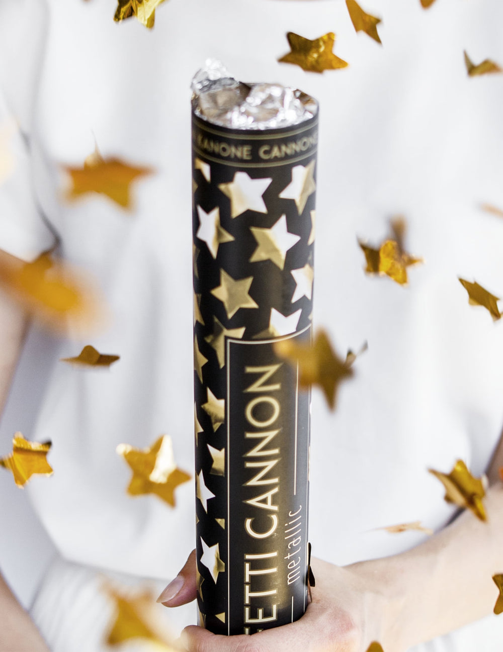 Mise en situation avec confettis en vol du canon à confettis étoiles métallisées dorées
