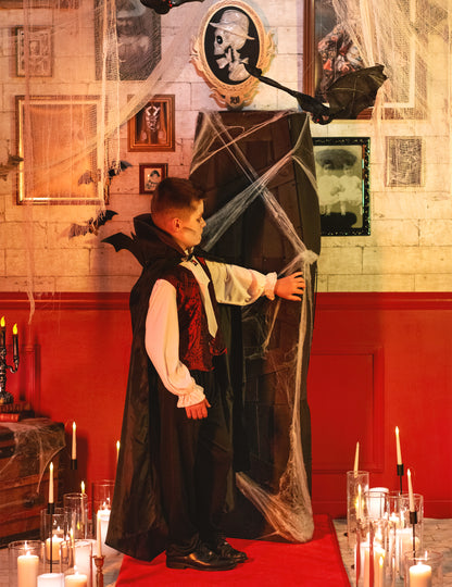 Profil nézet egy gyerek vámpírral a Halloween koporsó dekorációhoz fehér pókhálóval