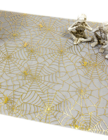 Gros plan sur le motif doré du chemin de table toile d'araignée pour Halloween