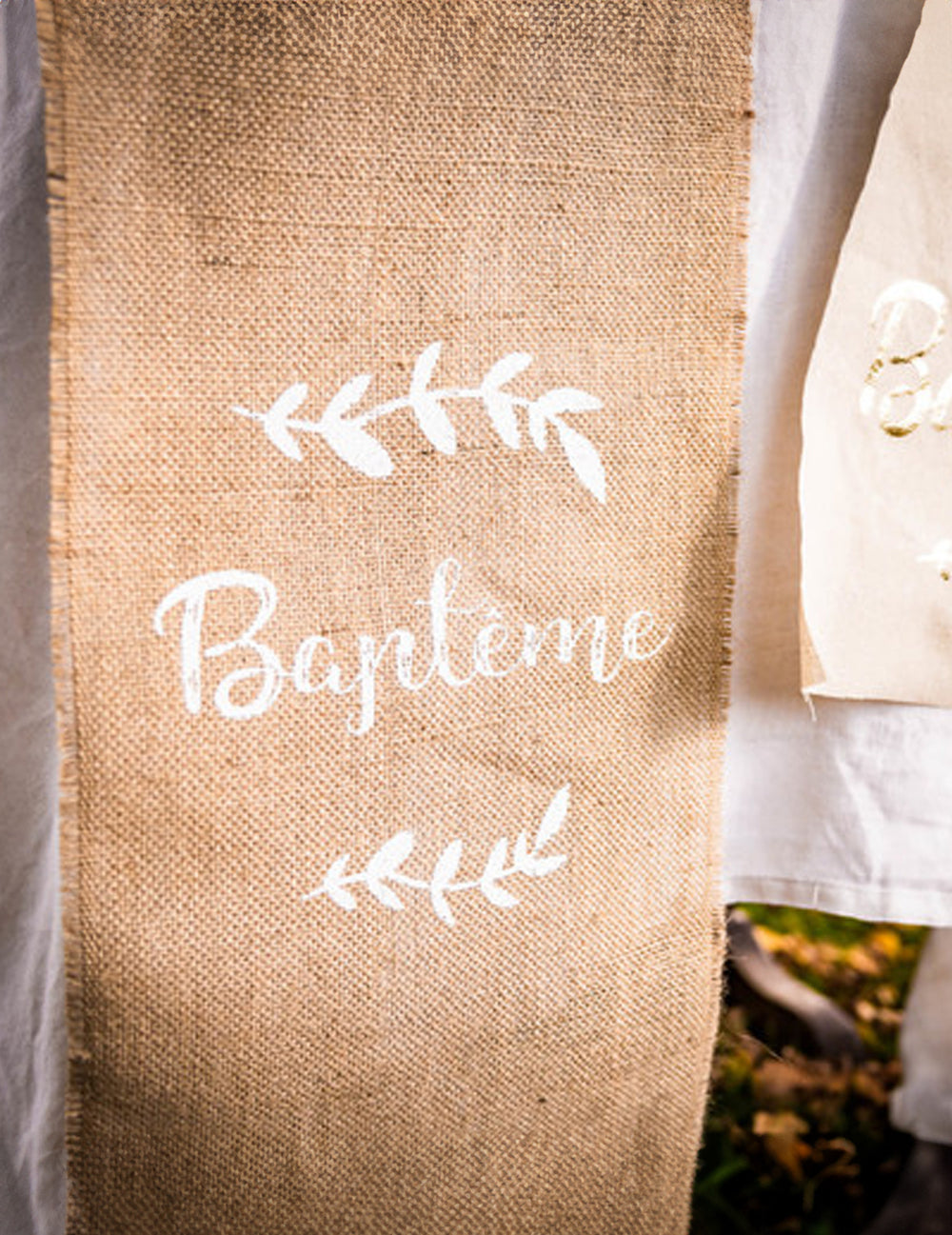 Détail de l'inscription du chemin de table baptême et feuillages pour fête