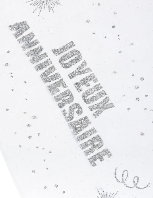 Gros plan sur l'inscription du chemin de table organza Joyeux anniversaire argent pailleté